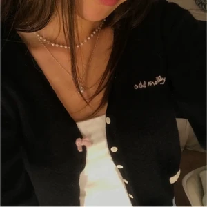 Svart Odd Molly kofta - Odd Molly kofta, svart med vita knappar och en rosa rosett samt rosa detalj vid mudden av ärmen (bild 3). Materialet består av lammull. Vet inte riktigt vilken storlek men jag skulle säga att den är en XXS.Skriv gärna för fler bilder! Kan mötas upp eller 