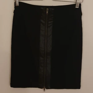 Kjol med dragkedja - En kjol med en fungerande dragkedja och en läderdetalj, aldrig använd dvs. i nyskick.