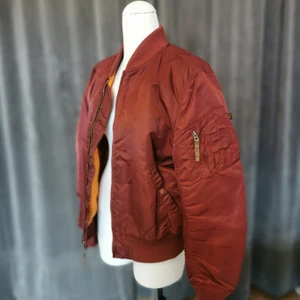 Alpha industries bomberjacka, burgundy/röd - Använd men i bra skick. Passformen är ganska stor, alltså inte en tajt jacka. Orange innerfoder. 