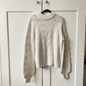 Vit stickad tröja från Gina - Kritvit stickad tröja från Gina i mjukt och tjockt material. Mäster på framsidan och armarna. Ballongiga armar och relativt hög krage. Storlek XS men passar även S. Använd endast 1 gång.