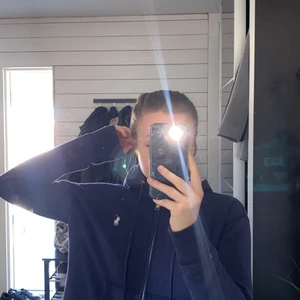 Ralph Lauren Hoodie med dragkedja  - Jättefin marinblå hoodie med dragkedja från Ralp lauren. Köpt i USA på en outlet så den är förstås äkta. Inte använd alls mycket men säljer den för jag inte har så mycket användning av den 