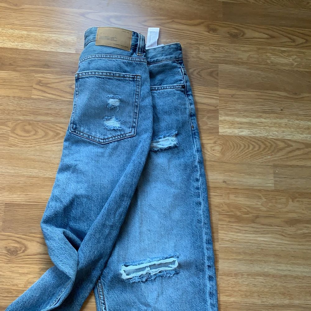 Säljer ett par nya blåa mom jeans från bershka. Dessa byxor är i storleken 42 och är helt nya! Säljs pågrund av fel storlek!. Jeans & Byxor.