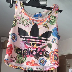 En åkta. Blommiga Adidas kroptop  - I mycket bra skick och passar xs_s.man Kan have de som en frittid T.SHIRT eller en topp.finns fler bilder 