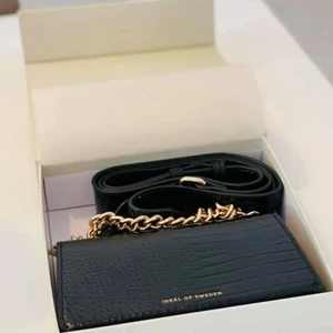Handväska från iDeal of Sweden  - Svart handväska från märket Ideal of Sweden, äkta! Helt NY! Nypris: 899kr! Hämtas i Lessebo eller fraktas mot fraktkostnad spårbar 66kr extra. Filmar alltid när jag postar, eller skickar med spårbar frakt. Skriver alltid avs! Jag garanterar en snabb och pålitlig affär! 🎀