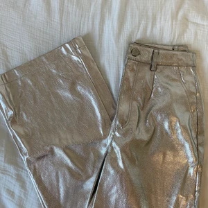 Silvriga byxor - Modellen är som ett par kostymbyxor, skit snygga till fest. Tajtare upptill och utsvängda i benen, aldrig använda 