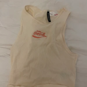 Gulligt linne  - Gulligt croppat linne från H&M med en coca cola symbol. Jättebra skick då det är knappt använt. Skriv privat för fler bilder 💓