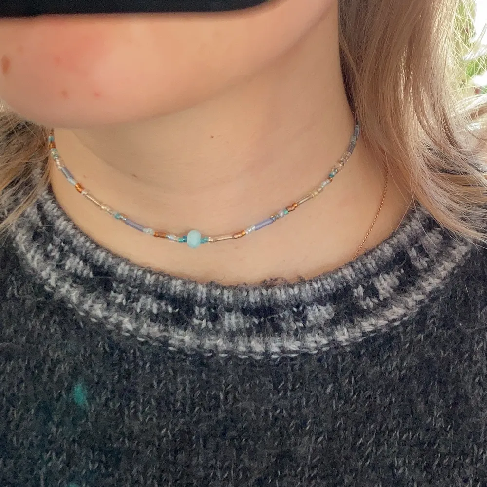 Halsband med blå/ bruna pärlor och en ljusblå sötvattenspärla . Accessoarer.