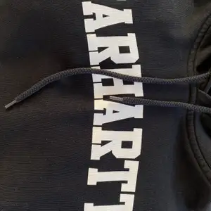 Svart hoodie från carhartt med tryck över bröstey | strl M | carhartts vanliga ’hårda’ material | använd  | nypris 899kr | frakt tillkommer