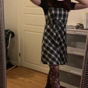 Svart vit rutig klänning på spaghetti straps - Den går att knyta runt om framme eller bak vad man själv tycker e bättre, den har tre knappar på ryggen så man kan knäppa klänningen. 