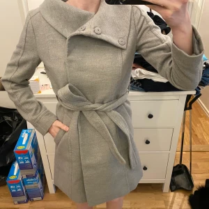 Grå ullkappa h&m - Använd fåtal gånger. I nyskick. Från h&m. Strl small. Köparen betalar fraktkostnaden på ca 60kr.