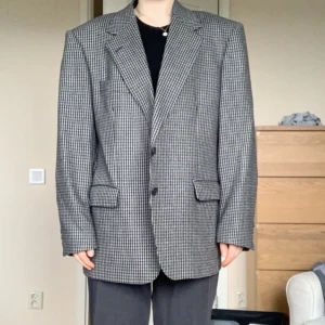 Hundtandsmönstrad kavaj i perfekt skick - En oversized blazer som passar storlek S-XL beroende på vilken fit man vill ha. Den är vintage men har inga tecken på att ha varit använd. Säljes på grund av att den är lite stor på mig.