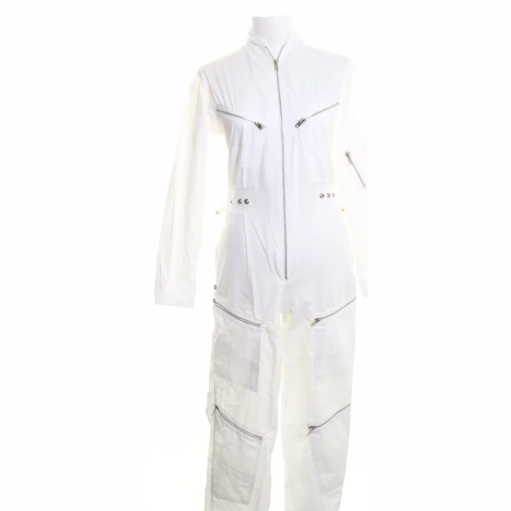 Workwear boilersuit i vitt med fickor och dragkedjor. Har även funktion i midjan för att få den att sitta perfekt!  Storlek 34 Märke Claude Charel  . Jeans & Byxor.