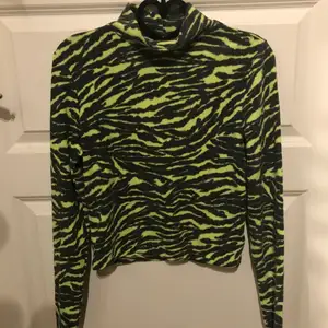 Polotröja med Tiger print i neon grön och grå från h&m. Fleece tyg varm. Inte så stretchig 
