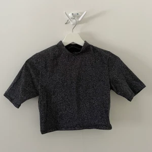 Glittrig croppad polotopp - Glittrig croppad polotopp från PULL&BEAR. Storlek M men är mer som S.