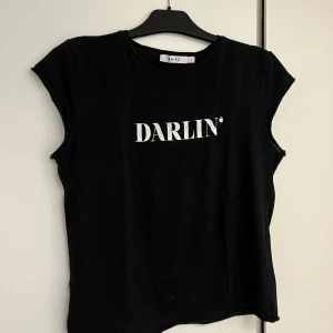T-shirt - Svart t-shirt med trycket darling, trycket är lite sprucket men tröjan är annars i bra skick