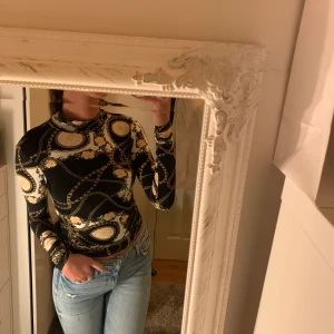 Topp med mönster - Topp med möster och hög hals. Skönt material. Använd 3-4 gånger men i nyskick.