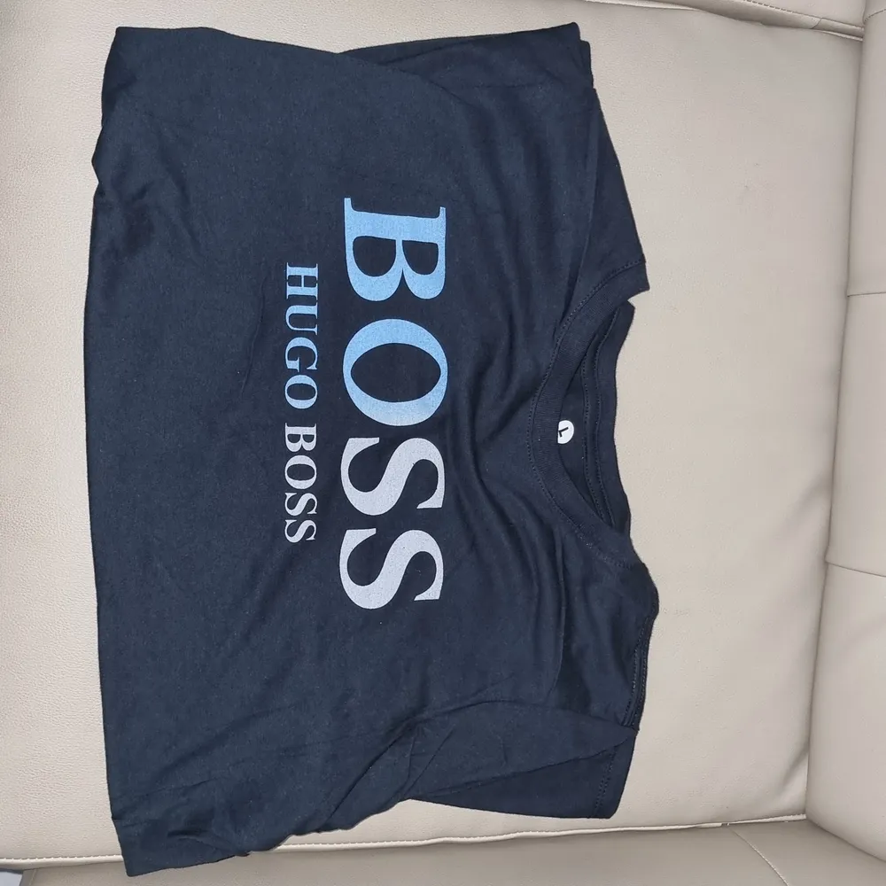 Ytterligare en oanvänd Hugo Boss t-shirt med centrerad text och svartblå bakgrund. Simpel design fu kar med det mästa. Framhäver dina armar och är väldigt behaglig att ha på sig.       (!Tar häldst swish!). T-shirts.