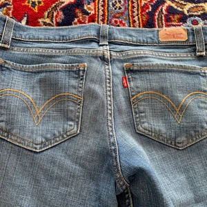 Lågmidjade Levis jeans - Så snygga utsvängda lågmidjade jeans från Levis! Tyvärr lite korta på mig, är 175 och har långa ben. Innerbenslängd: 82 midjemått: ca 82 cm    Buda i kommentarerna💕 Köparen står för frakt! Avslutas måndag!