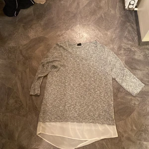 tröja  - grå tröja med detalj, ärmarna är inte i full längd! köpt på gina, storlek M. knappt använt säljes för 30kr exl.frakt 