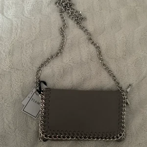 Grå tiamo väska  - En liten grå tiamo väska som jag aldrig använt.