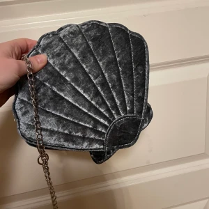 Axelremsväska  - Axelremsväska formad som en snäcka med blixtlås🦋 får plats med alla nödvändiga saker! Hör av er vid funderingar 💕💕