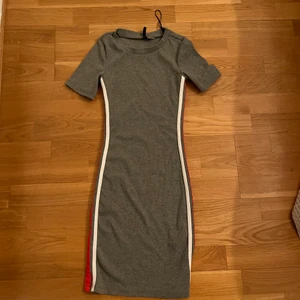 Klänning hm - Tight klänning från hm med vita/röda ränder på sidan. Klänningen har inga anmärkningar, använd några gånger