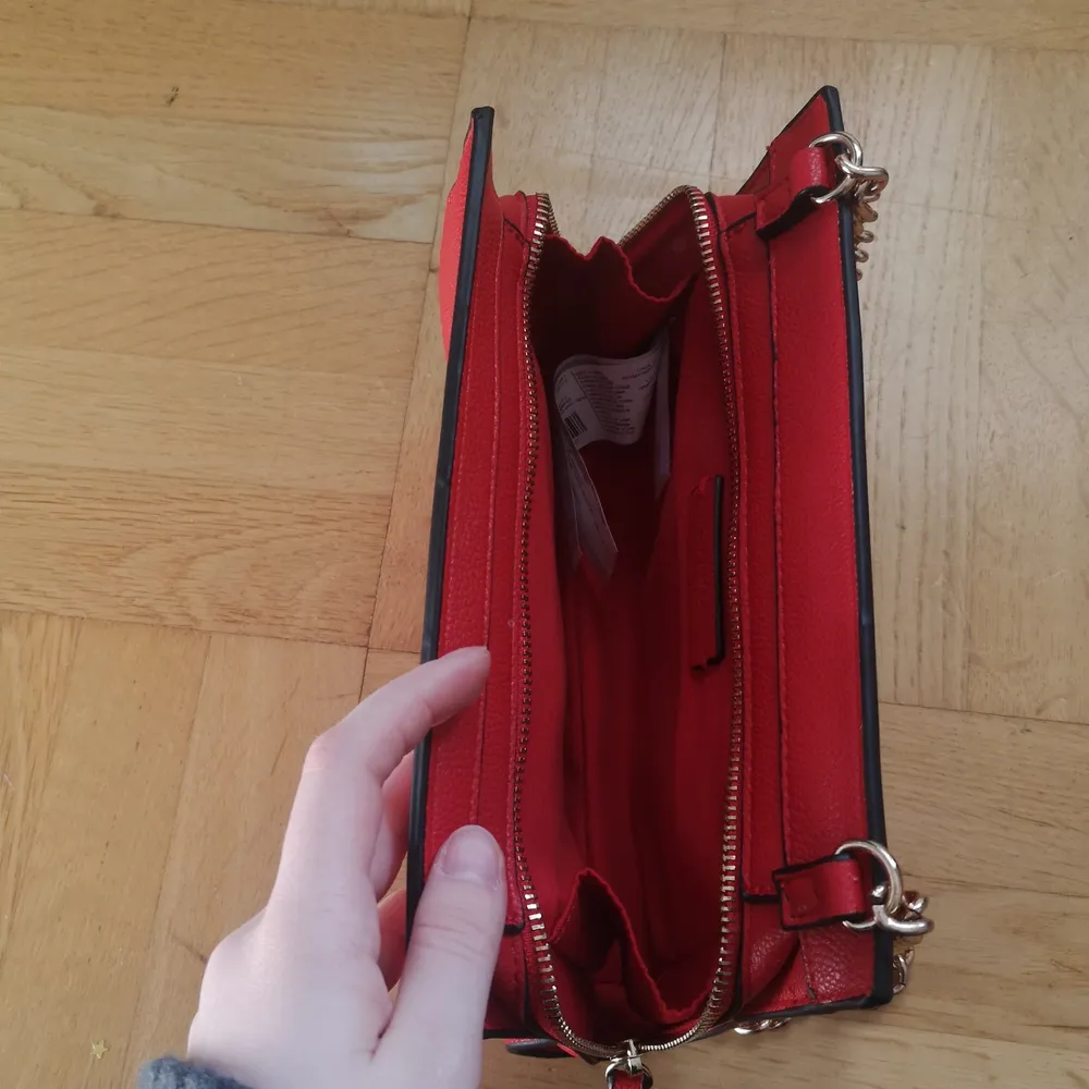 En liten röd handväska med dragkedjan . Väskor.
