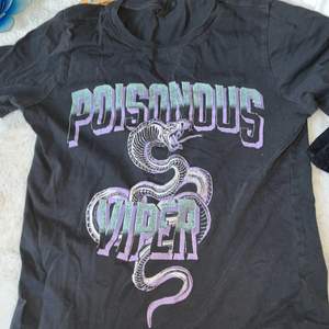 T-shirt från Gina tricot med ett orm tryck i lila och turqoise. Storlek xxs.