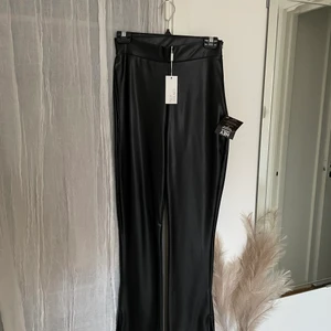Läder byxor med dragkedja vid sidan - Oanvände läder byxor ifrån Nelly i storlek S 