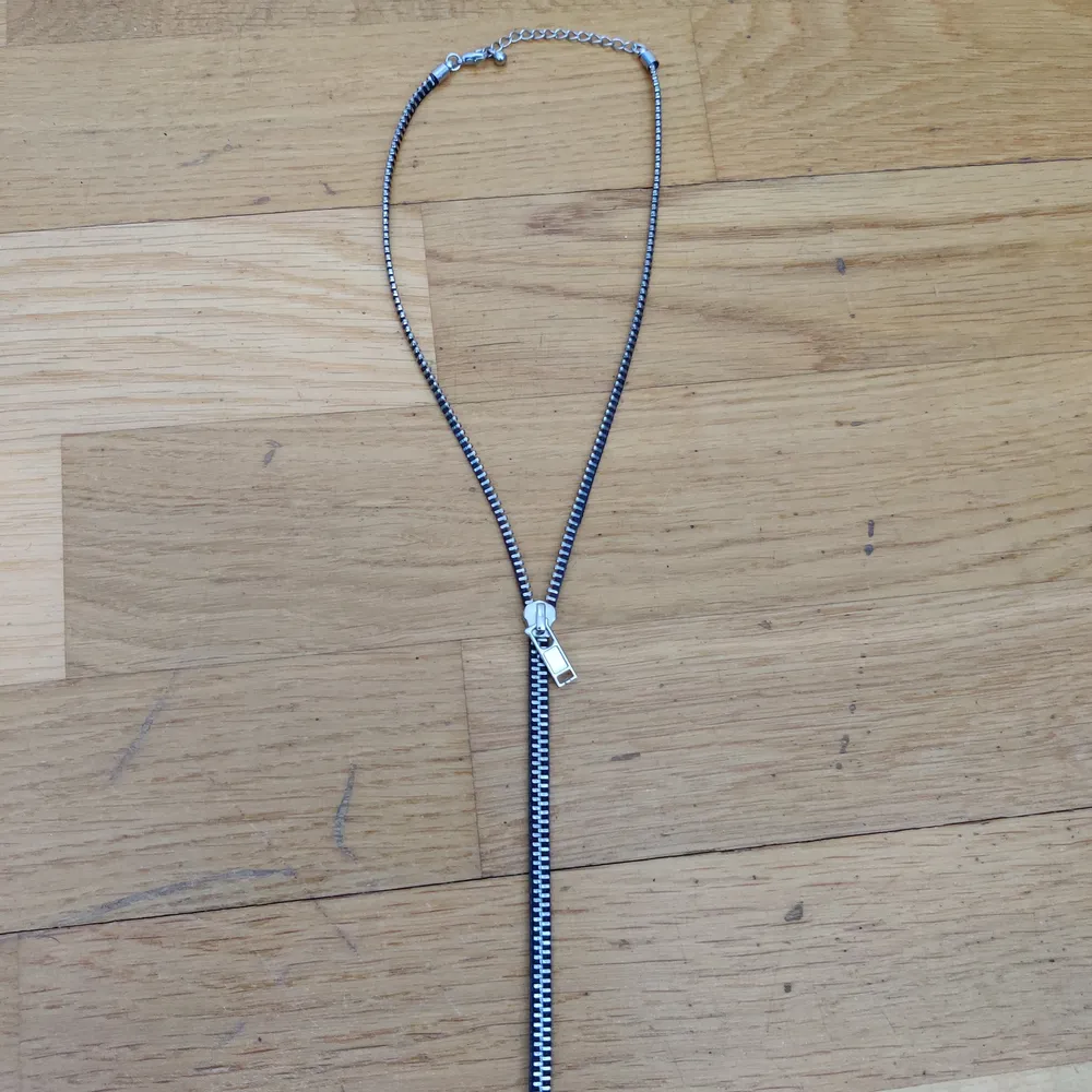 Ett halsband som ser ut som en dragkedja, man kan dra upp dragkedjan hela vägen upp och hela vägen ner. Fint skick, använd en gång och testad. Kommer från Glitter och man kan justera storleken om man vill. (Köparen står för frakten). Accessoarer.