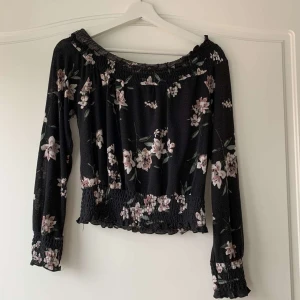 Offshoulder blus - Så fin blus som är offshoulder. Från Gina tricot i storlek xs. Den är svart och har fina rosa blommor på sig och sitter så fint på. Säljs för att den inte längre används då den är för liten, priset kan diskuteras💕💕
