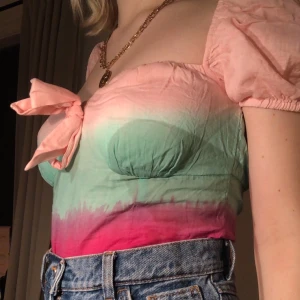 Blus - Söt, lite tiedie aktig blus med puffiga ärmar och rosett på bröstet. Dragkedja i sidan. Lite stor på mig. Endast använd ett fåtal gånger.