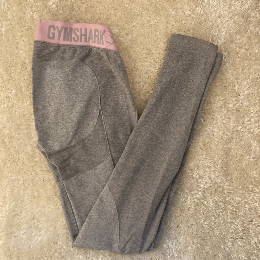 Säljer dessa ljusgråa tights från gymshark med rosa mudd. Dom är så sköna och stretchiga och är nästintill oanvända, jag säljer dom pga att jag har växt ur dom! Köparen står för frakten! . Jeans & Byxor.