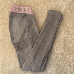  gymshark tights - Säljer dessa ljusgråa tights från gymshark med rosa mudd. Dom är så sköna och stretchiga och är nästintill oanvända, jag säljer dom pga att jag har växt ur dom! Köparen står för frakten! 