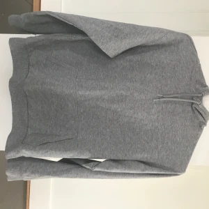 Grå hoodie - Grå hoodie från asos som passar perfekt en sval sommarkväll då den är ganska tunn. Strl. 36