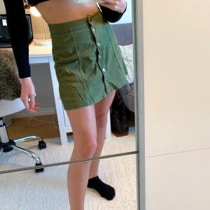 Jeanskjol, militärgrön  - En jeanskjol i militärgrönt, använd fåtal gånger då den är för stor i midjan på mig (har strl 34). Passar superbra nu till våren och sommaren!