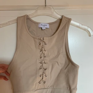 Beige topp - Använd ett fåtal gånger. Superskönt material och snörningen är en snygg detalj. Storlek s för 40 kr + frakt, Dm för frågor