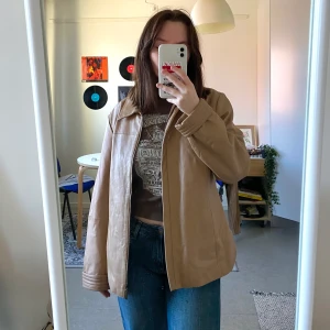 Beige jacka - Snygg beige vår-jacka i skinnimitaion. Det står ingen storlek men kan passa allt från XS-L beroende på önskad passform (jag har vanligtvis S). Från kappahl men är en äldre modell, väldigt bra skick. Jag står för frakt!💟