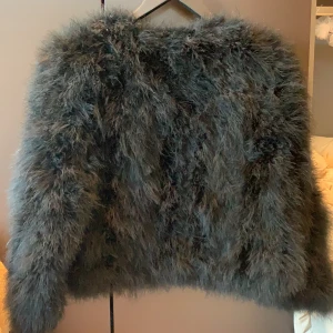 Jacka av strutsdun - Festlig jacka som är perfekt att ha över en klänning! Helsvart med innerfoder i satin. Använd sparsamt och i superfint skick. 