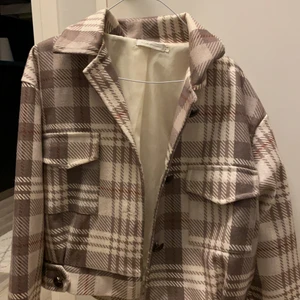 Jacka  - En lite kortare jacka som går till midjan på mig. Knappar för att stänga med, står storlek ”14” men sitter som en M-L. Använd men fortfarande fin! Har ett litet hål på insidan. 