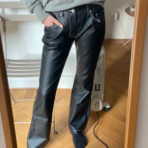 Skinnbyxor  - Säljer dessa superfina byxor i en skinnimitation med vita sömmar. Raka i modellen och lågmidjade - dösnygga!! Jag är 168 cm för längreferens och de faller så snyggt över skor! 