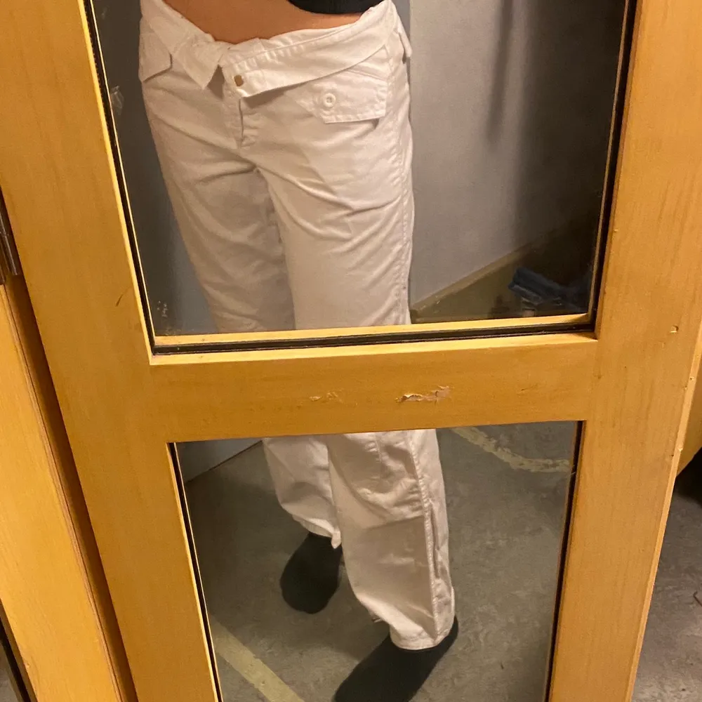 Ett par fina vita cargo pants med detaljer längst ner, på benen och svanken. Mellanhög midja, jag har vikt ner kanten vilket är väldigt snyggt på dessa byxor. De är inte så genomskinliga, rättvisa bilder. Skriv vid intresse☺️💓. Jeans & Byxor.