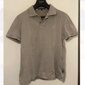 Grå/beige piké Tiger of Sweden - Piké från Tiger of Sweden i en cool beigegrå färg. Frakt tillkommer.