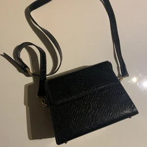 Väska - En superfin svart, lite kantig axelväska😊 Passar till allt! Har dessutom en axelrem som kan bytas ut. Pris 100 kr plus 45 kr frakt❤️