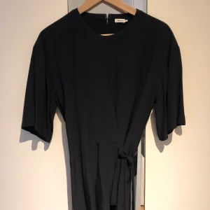 Filippa k blus - Svart blus från Filippa k som knyts omlott i midjan. Mycket fint skick. 