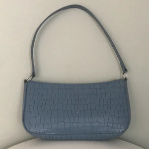 Axel väska - Axel väska från H&M använd typ 3 gånger och är i väldigt bra skick därför. Den är i väldigt fin pastell blå men lite silver detaljer. Säljer denna för att jag är i behov av pengar och har redan tillräckligt många väskor. Ordinarie pris: 149 frakt ingår EJ 