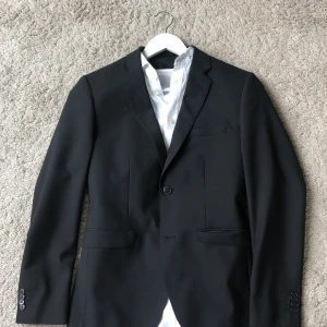 Bläck kostym i mycket bra skick strl. 46 - Hej, jag säljer min kostym som är endast använd en gång. Märket är bläck både på kavajen och kostymbyxorna. Storleken är 46 på båda. Nypris 1500 kr