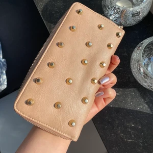 Plånbok  - En valentino inspererad plånbok ifrån märkes Ulrikas✨Den har har en dusty pink färg  , mörkare på vissa ställen som en cool effekt , guldiga nitar✨ vanligt slitage förutom på dragkedjorna dom är slitna se bild nr 2 , byter man dragkedjor är det en jättefin plånbok✨