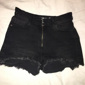 Svarta shorts - Svarta denimshorts från FBSister storlek S. Hög midja men korta. Snygga på! Dragkedja fram. 5 fickor, gott skick, dock tre små vita prickar längst ned på ena sidan bak. Fransiga i benslut.