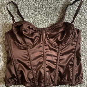 Brun korset topp size xs/xxs - Sött brun korset topp från Urban outfitters, som tyvärr är förliten för mig! Står att den är storlek s men skulle säga att den är xs eller xxs🥰 Skriv vid intresse och frågor, och vid önskan av fler bilder så löser jag det!
